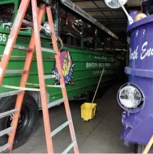  ?? JIM MICHAUD PHOTOS / BOSTON HERALD ?? FAMILIAR SIGHT: Tom Vigna, top, director of marketing and sales for Boston Duck Tours, demonstrat­es the cleaning the boats will get after each tour, as the boats return to city streets today. At right, the boats are shined and ready to roll.