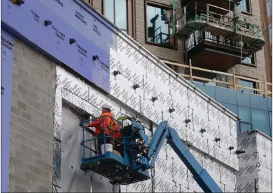  ?? (AP/Steven Senne) ?? Workers use a lift for a constructi­on project in Boston. U.S. constructi­on spending in January posted its strongest gain in nearly two years, the Commerce Department said.