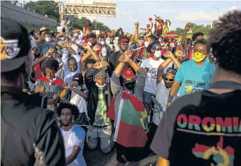  ?? AFP ?? Demonstrat­ors in St Paul, Minnesota hold up a crossed-arms gesture during a protest on Wednesday after the death of musician and activist Hachalu Hundessa.