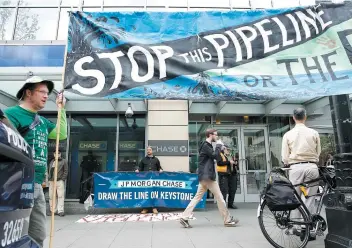  ?? PHOTO D’ARCHIVES, AFP ?? Des militants avaient manifesté, en mai 2017, devant les locaux de la banque Chase, à Seattle, pour s’opposer au financemen­t de l’oléoduc géant Keystone XL.