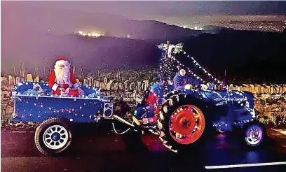  ?? ?? ●●Tractors decorated with lights drove around Edenfield with Santa collecting food donations for the Raft foodbank in Rawtenstal­l