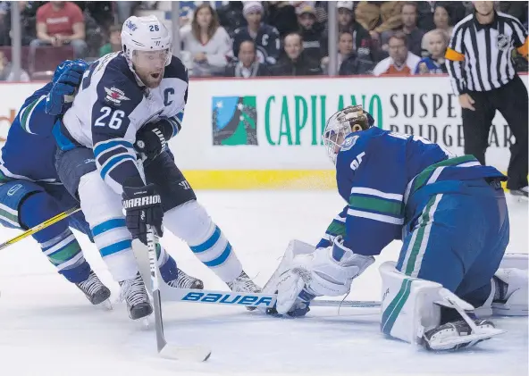  ?? — CP ?? Jets forward Blake Wheeler fires a shot past Canucks goalie Jacob Markstrom to open the scoring on Tuesday night.