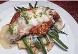  ?? ?? The Parmesan-crusted fried chicken sitting atop green beans was topped with lemon butter herb sauce.