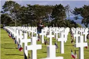  ?? ASSOCIATED PRESS JEREMIAS GONZALEZ / ?? A woman holds a bouquet of roses during the 78th anniversar­y of D-Day ceremony, in the Normandy American Cemetery and Memorial of Colleville-sur-Mer, overlookin­g Omaha Beach, Monday.