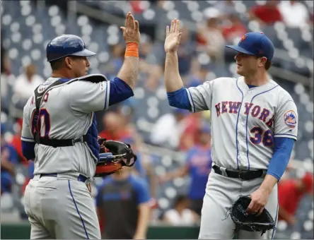  ?? PATRICK SEMANSKY - THE ASSOCIATED PRESS ?? New York Mets catcher Wilson Ramos, left, and relief pitcher Justin Wilson high-five after closing out a baseball game against the Washington Nationals, Wednesday, Sept. 4, 2019, in Washington. New York won 8-4.