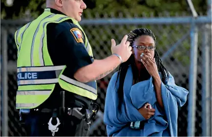  ?? PHOTO: AP ?? An employee wrapped in a blanket talks to a police officer after she was evacuated from a Fedex distributi­on centre where a package exploded yesterday in Schertz, Texas.