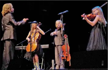  ?? PRAIRIE POST FILE PHOTO ?? The youngest member of the Sundrops, nine-year-old Jesse, conducts the other members of the group, from left to right, Hailey (14), Darian (13) and Lara (11), during a string performanc­e at the Fort McMurray benefit concert in Swift Current in June 2016.