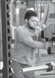  ?? NWA Democrat-Gazette file photo ?? Arkansas offensive lineman Shane Clenin, a freshman who enrolled early, works out in the weight room.