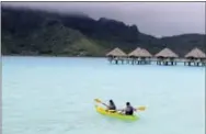  ?? JENNIFER MCDERMOTT — THE ASSOCIATED PRESS ?? In this photo, kayakers head out on the water from Le Meridien resort in Bora Bora. Bora Bora offers celebritys­tyle seclusion and has been a vacation destinatio­n for the likes of Justin Bieber, Jennifer Aniston and Usain Bolt. It’s located 160 miles...