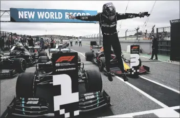  ?? ASSOCIATED PRESS ?? MERCEDES DRIVER LEWIS HAMILTON of Britain jumps out of his car after his record breaking 92nd win at the Formula One Portuguese Grand Prix at the Algarve Internatio­nal Circuit in Portimao, Portugal, on Sunday.