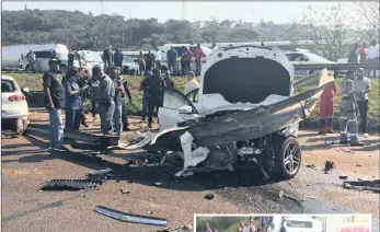  ??  ?? GETAWAY CAR: Police officers and rescue workers at the scene of the smash, near the Mercedes-Benz that was used by the suspects. The vehicle had been hijacked in Reservoir Hills.