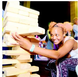  ??  ?? Petergaye Wright testing her balancing skills with a game of Jenga.