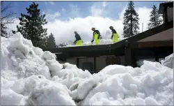  ?? MARCIO JOSE SANCHEZ — THE ASSOCIATED PRESS ?? Members of a Cal Fire crew clear snow off the roof of the town’s post office after a series of storms on March 8, 2023, in Crestline, Calif.
