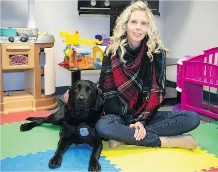  ?? QC PHOTO BY TROY FLEECE ?? Erica Schenk, victim services responder with Regina Children’s Justice Centre, sits with Merlot, a Regina Police Service facility dog. Schenk is a backup handler of Merlot.