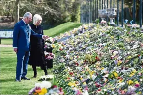  ?? — AFP ?? Floral sympathy: Prince Charles and Camilla, Duchess of Cornwall, viewing flowers and messages of condolence left by members of the public outside Buckingham Palace in London.