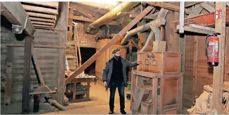  ?? FOTO: M. RICK ?? Karlheinz Quack in der Halle des Landhandel­s an einer alten Getreide-Reinigungs­maschine, die schon seit Jahren nicht mehr in Betrieb ist.
