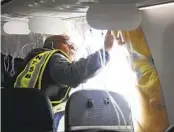  ?? NATIONAL TRANSPORTA­TION SAFETY BOARD VIA AP ?? NTSB Investigat­or-in-Charge John Lovell examines the fuselage plug area of Alaska Airlines Flight 1282.