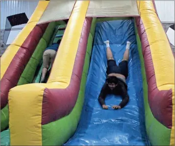  ?? Kevin myrick/ Standard Journal ?? A Cedartown Middle School students slid head first through one portion of an inflatable obstacle course setup in the school’s gym for students to use as part of an exercise getting them to think about what challenges they’ll face in the academic year...