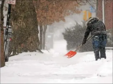  ?? GENE WALSH — DIGITAL FIRST MEDIA ?? A woman clears her sidewalk of snow Thursday.