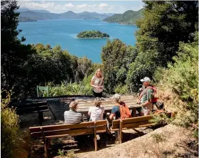  ?? ?? Ross demonstrat­es the value of trapping to visitors at the scenic lookout on Kaipupu.