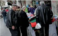  ?? — Reuters ?? People shop on a main market street in Athens.