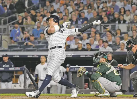  ?? PHOTOS BY BILL KOSTROUN/ASSOCIATED PRESS ?? The Yankees’ Aaron Judge follows through on a two-run home run against the Athletics during the first inning of the American League wild-card playoff game Wednesday in New York.