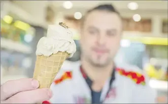  ?? Picture: MARIJAN MURAT/DPA VIA AP ?? Thomas Micolino, owner of Eiscafe Rino, holds an ice cream cone in Rottenburg am Neckar, Germany. A German ice cream parlor is selling a new kind of special treat: insect flavor with dried brown crickets as topping.