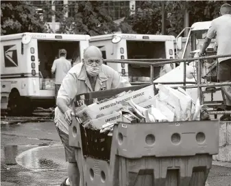  ?? J. Scott Applewhite / Associated Press ?? Letter carriers load mail trucks for deliveries at a U.S. Postal Service facility in McLean, Va. Delays caused by an increase in voting by mail may contribute to public doubts about the results.