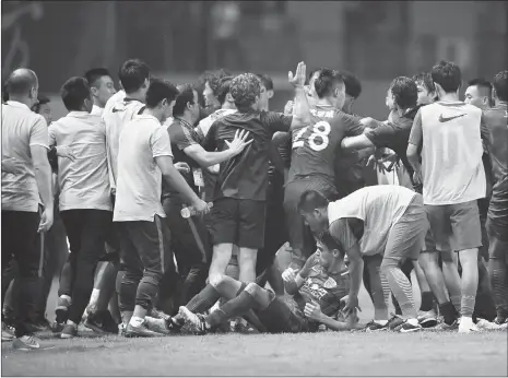  ??  ?? Players of Guangzhou R& F and Shanghai SIPG are involved in a mass brawl as SIPG midfielder Oscar lies on the ground during their Chinese Super League match on Sunday in Guangzhou, Guangdong Province.
