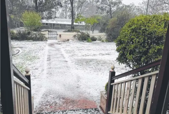  ?? ?? ALL WHITE: Highfields resident Gen Allpass captured the torrential downpour of hail that blanketed the front yard of her mother's home.