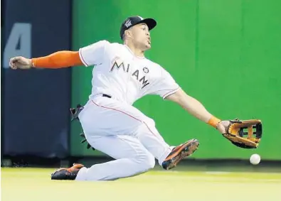  ?? WILFREDO LEE/AP ?? Miami right fielder Giancarlo Stanton is unable to catch a ball hit by Houston Astros’ Jose Altuve for a double during the ninth inning Wednesday. Altuve had two doubles and two triples in the game.