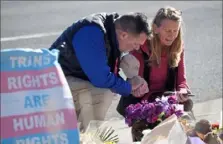  ?? Associated Press ?? An unidentifi­ed man consoles Renee Behr of Colorado Springs, Colo., after she placed a bouquet of flowers on a makeshift tribute Monday near the site of a mass shooting at a gay bar in Colorado Springs.