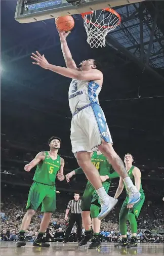  ?? Ronald Martinez Getty Images ?? NORTH CAROLINA’S Kennedy Meeks grabs one of his 14 rebounds as three Oregon players look on. Meeks had eight offensive rebounds and Tar Heels had 17, a recurring theme in their victory.