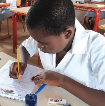  ??  ?? A student writing an exam