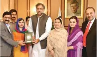  ?? PRESS INFORMATIO­N DEPARTMENT VIA AP ?? MENGGUGAH: Malala (tiga dari kiri) dengan didampingi ayah (kiri) dan ibu (tiga dari kanan) menerima suvenir dari PM Shahid Khaqan Abbasi.