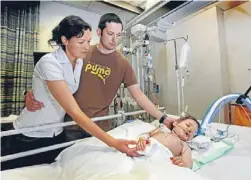  ??  ?? Bedside ritual: Katie and Bede Bailey in Wellington Hospital with Charlie at 20 months.