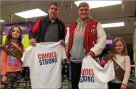  ??  ?? Reilly Luke, and Myla Brown, left and right, hand Cohoes Strong T-shirts to James Stott, second from left, and Arthur Stott, third from left.