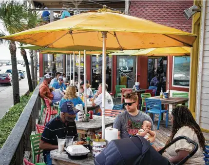  ?? Marie D. De Jesús / Staff photograph­er ?? Glenn Olsen, center, his 6-month-old daughter, Sunniva, and his wife, Jessica, have a late lunch together with family last week at The Spot in Galveston.