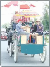  ?? —photo Gregg Chamberlai­n ?? Le maire de Hawkesbury Est Robert Kirby (à gauche) était armé d’un pulvérisat­eur à dos pour aider à rafraichir tous ceux qui étaient venus assister au défilé de la fête du Canada, dimanche après-midi à Chute-a-Blondeau.