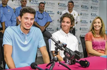  ?? LANNIS WATERS / THE PALM BEACH POST ?? Casey Staniszews­ki and his mom Chris Staniszews­ki listen as Matthew Byrne (left) talks about his rescue of Casey after a spearfishi­ng incident left him laying on the ocean floor without oxygen last month. St. Mary’s Medical Center honored Byrne and the team of people that helped to save Casey’s life Friday.