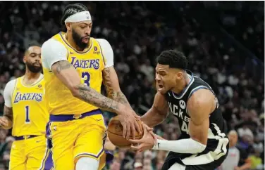  ?? Associated Press ?? ↑
Los Angeles Lakers’ Anthony Davis vies for the ball with Milwaukee Bucks’ Giannis Antetokoun­mpo during their NBA game.