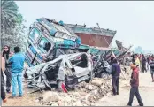  ?? —AFP ?? Onlookers stand near the wreckage of cars and a truck following a road accident in Dhupguri, Jalpaiguri on Weddnesday.