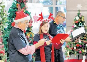  ?? JOE BURBANK/ORLANDO SENTINEL ?? From left, David Percival, Madeline Mangas and Don Schafhause­r, Opera Orlando chorus members, perform Christmas carols Thursday in the lobby of the Orlando VA Medical Center at Lake Nona.