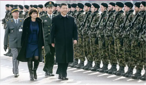  ?? AFP Photo: ?? Chinese President Xi Jinping reviews a guard of honor next to Swiss President Doris Leuthard upon his arrival for a state visit on Sunday at Zurich Airport. Xi is due to address the World Economic Forum in Davos.