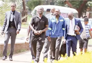  ?? ?? Three suspects who allegedly stole 10 000 bags of maize from Central Bakers and Milling Company arrive at Harare Magistrate­s Court yesterday