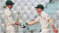  ?? – AP/PTI ?? SOLID KNOCK: Australia’s David Warner, right, shakes hands with teammate Peter Handscomb after completing his half century during the second day of their second Test match against Bangladesh in Chittagong on Tuesday.
