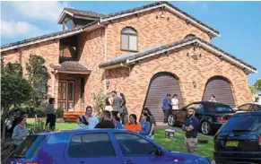  ?? — ap ?? On edge: people standing outside a house across the road from the Christ the Good shepherd church in western sydney, australia.