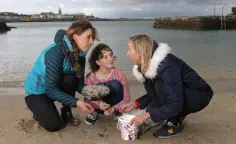  ??  ?? CLEAN-UP: Grainne Grehan, left, and Harriet Donnolly with daughter Flossie pick up plastic shards. Picture: Damien Eagers