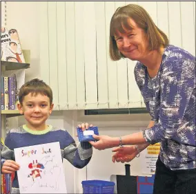  ??  ?? Jacob Matthews, who produced the winning poster in a competitio­n at Sapcote Community Library, was presented with a book token prize by the library chairman Lorraine Jackson