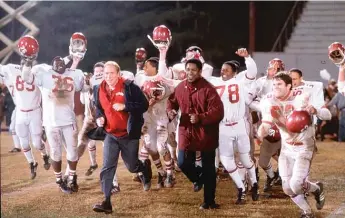  ?? WALT DISNEY CO. ?? Denzel Washington (right) stars as Coach Herman Boone and Will Patton stars as coach Bill Yoast in “Remember the Titans.” The film’s screenwrit­er, Gregory Allen Howard, has died at 70.